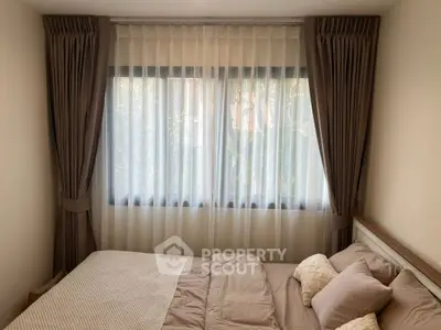 Cozy bedroom with elegant curtains and soft bedding, perfect for relaxation.