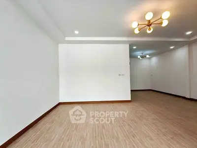 Spacious empty living room with modern lighting and wooden flooring