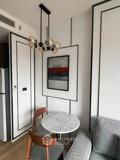 Modern living room with stylish decor and elegant lighting, featuring a cozy dining area and contemporary artwork.
