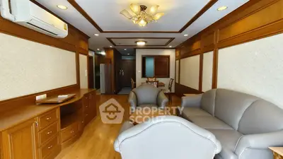 Spacious living room with elegant wood paneling and modern furniture, perfect for relaxation and entertainment.