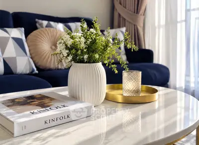 Stylish living room with elegant decor, featuring a marble coffee table, plush sofa, and natural light.