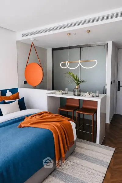 Modern bedroom with stylish decor and breakfast bar, featuring vibrant colors and contemporary lighting.