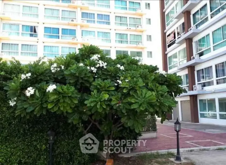 Modern apartment building exterior with lush greenery and well-maintained landscaping.