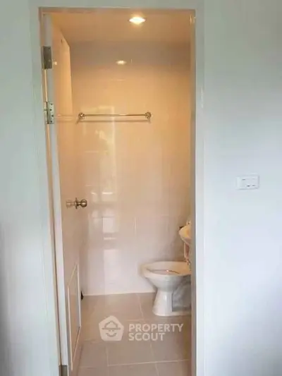 Compact bathroom with white tiles and modern fixtures in a cozy apartment.