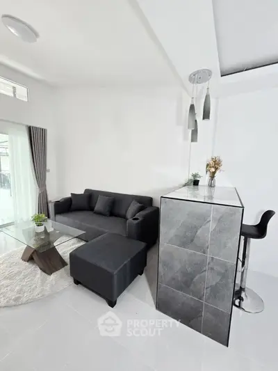 Modern living room with sleek gray sofa and stylish bar area, perfect for entertaining guests.