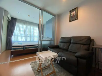 Modern studio apartment with cozy living area and bedroom separated by glass partition.