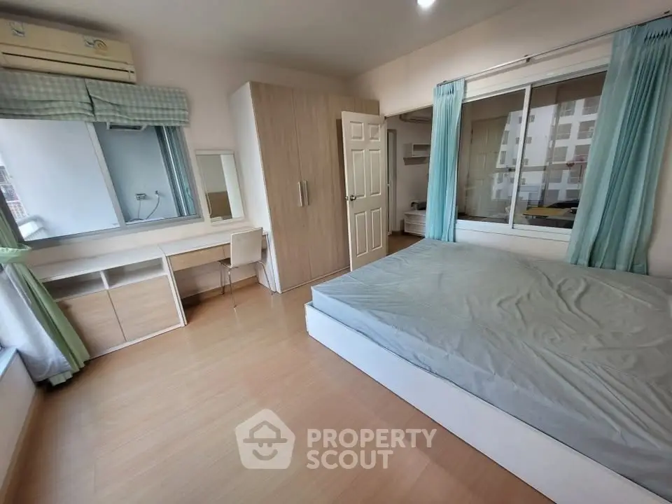 Spacious bedroom with modern furnishings and large window offering natural light.