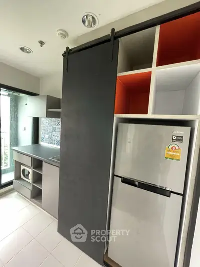 Modern kitchen with sliding door and built-in fridge in a stylish apartment