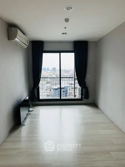 Spacious empty living room with city view and large window, ideal for customization.