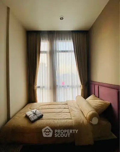 Cozy bedroom with elegant curtains and soft lighting, perfect for relaxation.