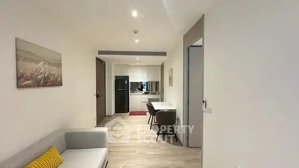 Modern open-plan living room with sleek kitchen and cozy seating area, perfect for urban living.