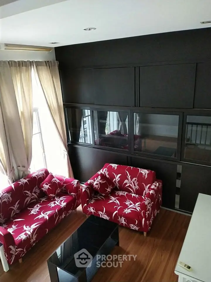 Stylish living room with red floral sofas and modern black accents