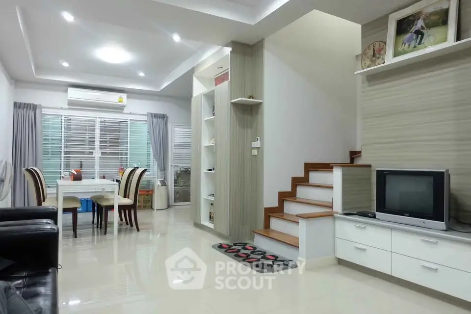 Modern living room with dining area and staircase in stylish home