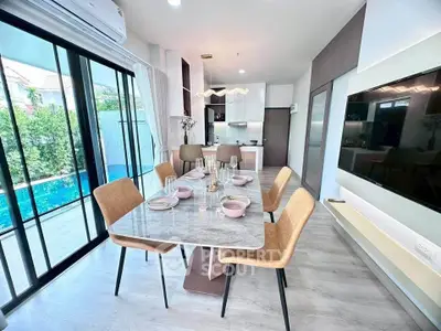 Modern dining area with pool view and sleek kitchen design