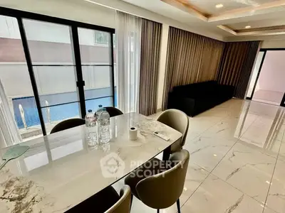 Luxurious modern living room with pool view and elegant marble flooring.