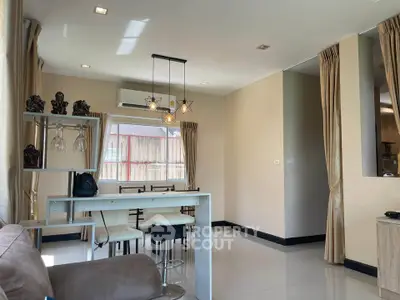 Modern open-plan living and dining area with stylish lighting and neutral decor.