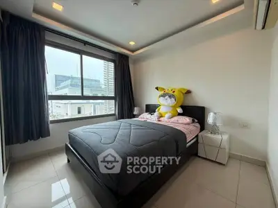 Modern bedroom with large window and plush toy on bed, offering city views and sleek design.
