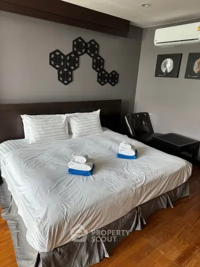 Modern bedroom with stylish decor and comfortable bedding in a cozy real estate property.