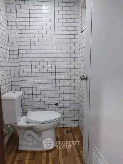 Modern bathroom with white subway tiles and wooden floor