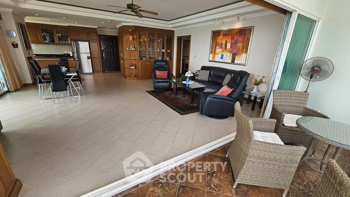 Spacious open-plan living room with modern kitchen and cozy balcony seating.