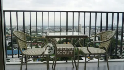 Stunning balcony view with outdoor seating overlooking city skyline, perfect for relaxation.