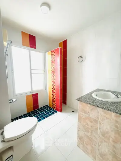 Bright modern bathroom with colorful tiles and natural light