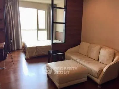 Cozy studio apartment with modern furnishings and large window for natural light.