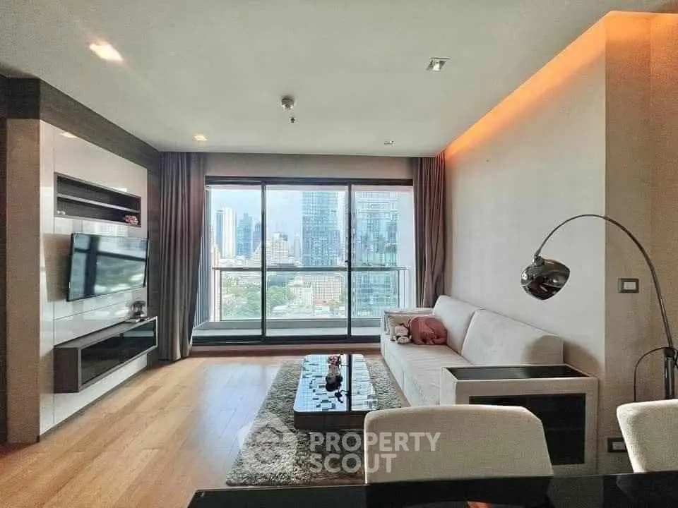 Modern living room with city view, featuring sleek furniture and large windows.
