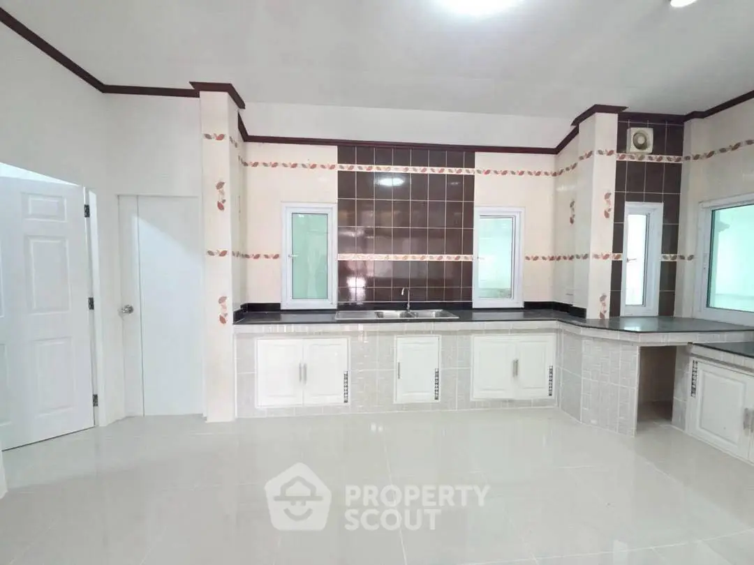 Spacious modern kitchen with sleek countertops and ample storage in a bright, airy setting.
