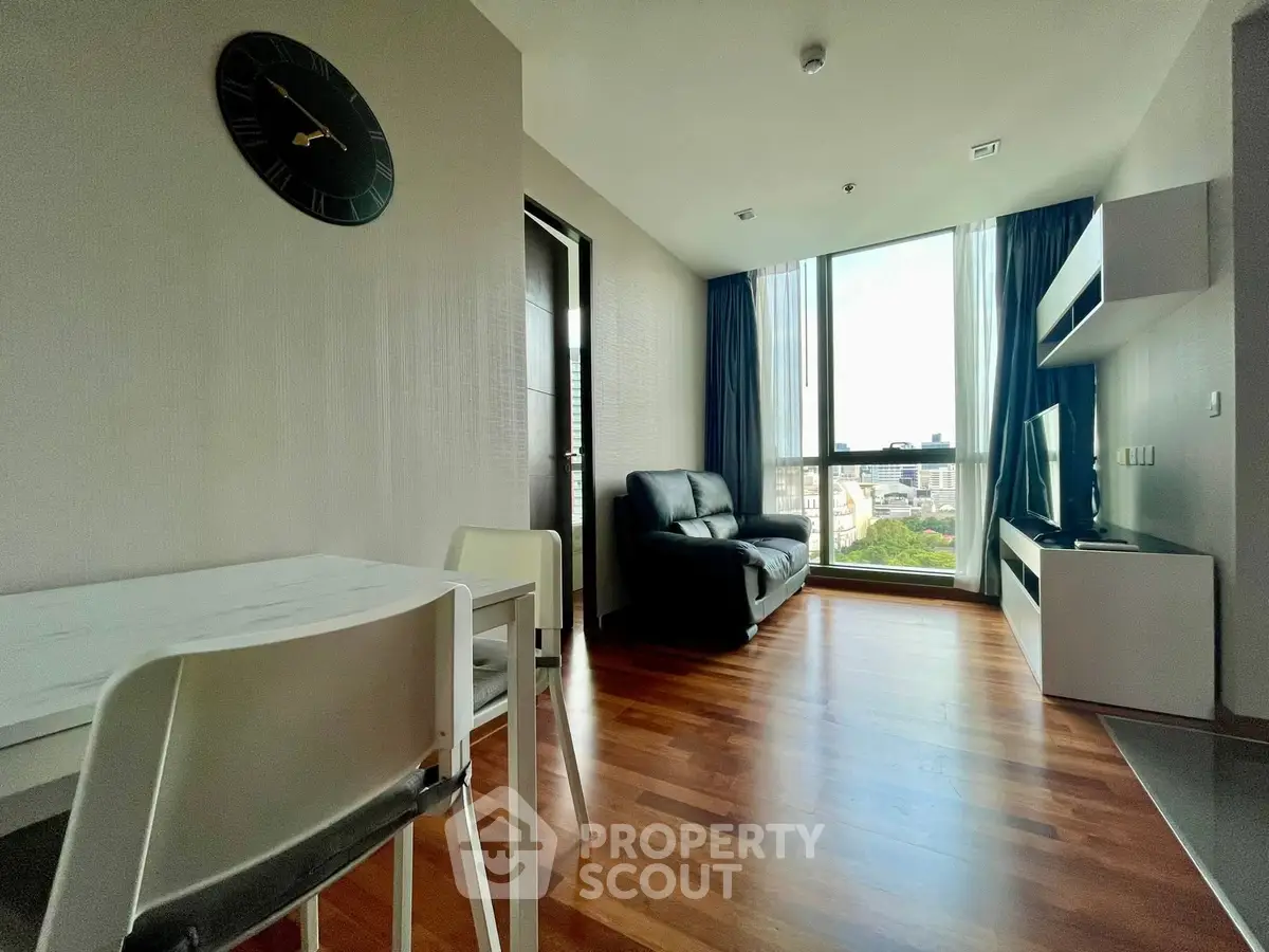 Modern living room with wooden flooring and large window offering city view