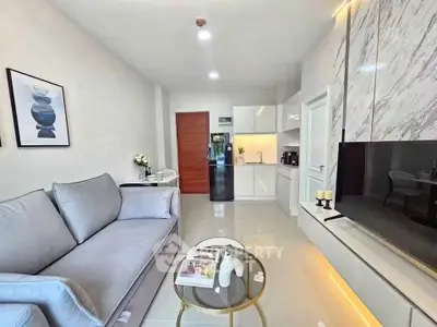 Modern living room with sleek design, featuring a cozy sofa, stylish decor, and a contemporary kitchen area.