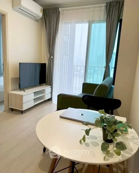 Modern living room with sleek furniture and large window offering natural light.