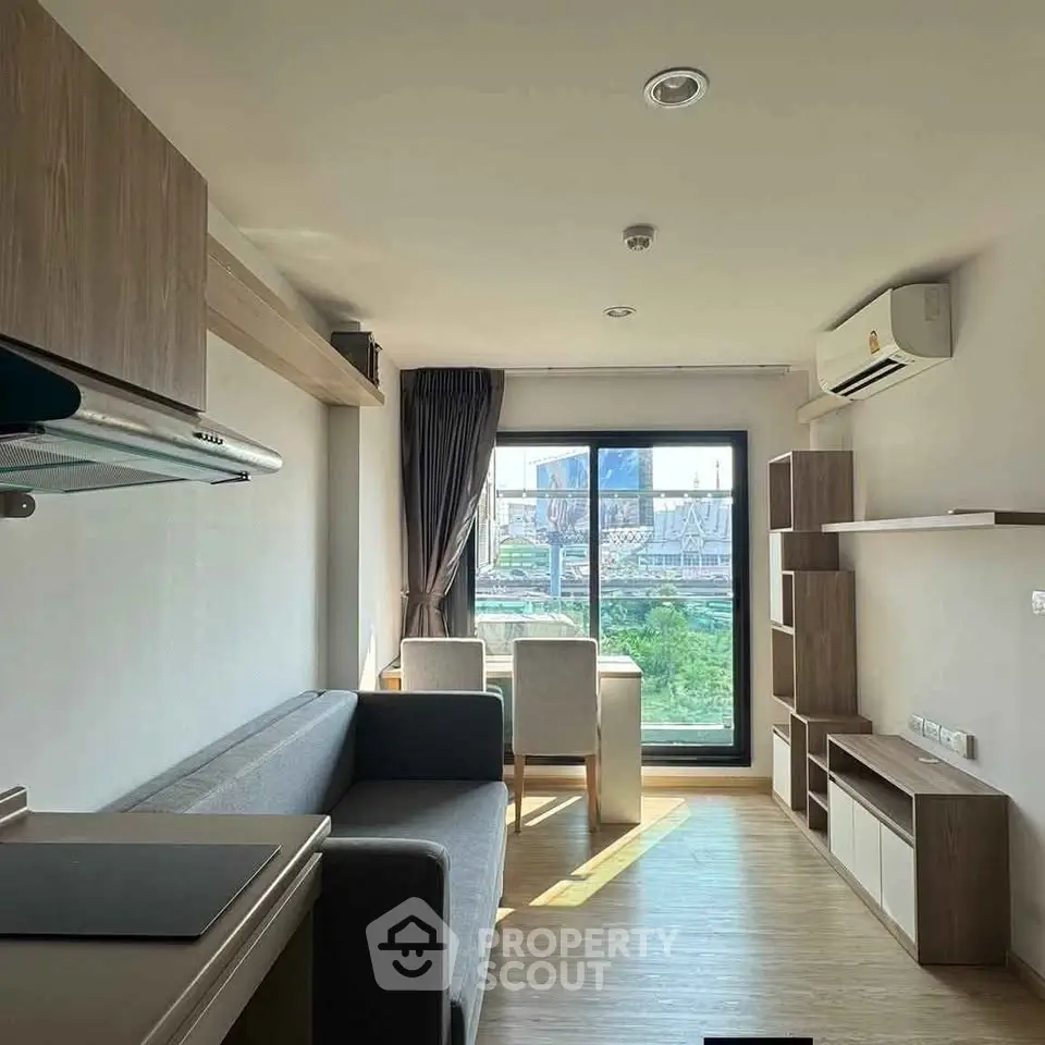 Modern living room with city view, featuring sleek furniture and natural light.