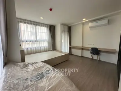 Modern bedroom with large windows and sleek furniture in a stylish apartment.