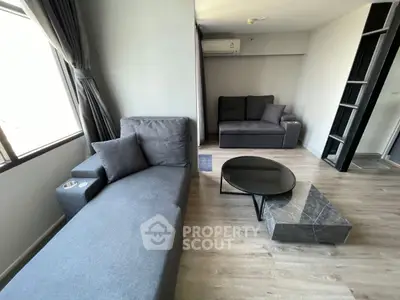 Modern living room with stylish gray furniture and sleek wooden flooring, perfect for relaxation and entertainment.