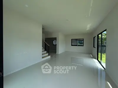 Spacious modern living room with large windows and glossy tiled floors