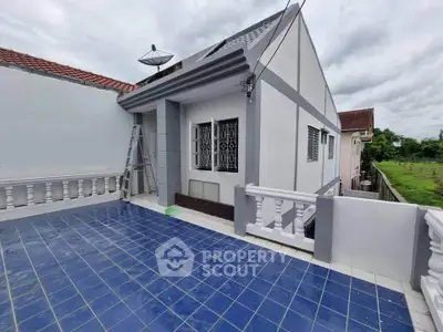 Charming single-story home with spacious blue-tiled terrace and modern exterior design.