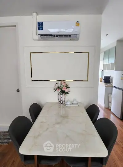 Chic dining area with marble table and modern kitchen in stylish apartment