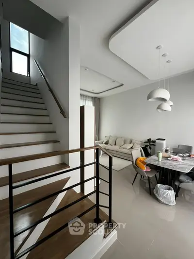 Modern living room with staircase and dining area in stylish home