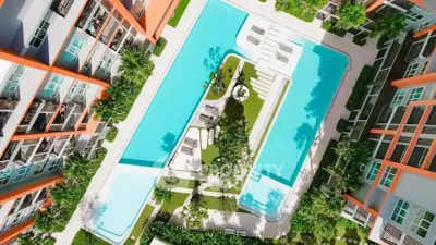 Stunning aerial view of modern apartment complex with large swimming pool and lush greenery.