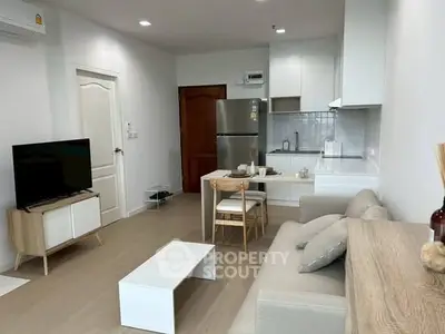 Modern living room with cozy sofa, dining area, and sleek kitchen in open layout apartment.