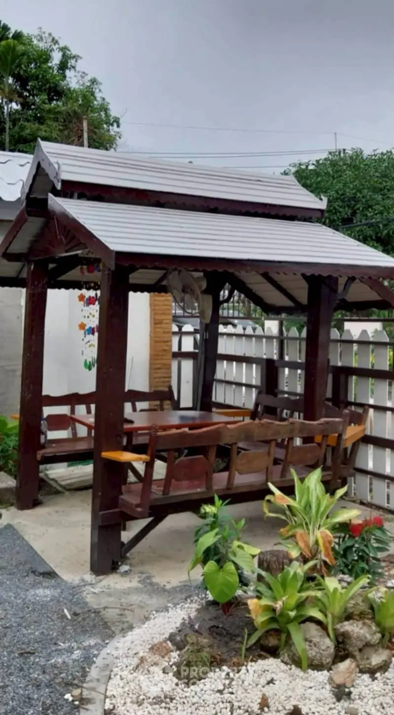 Charming garden gazebo with wooden seating and lush greenery
