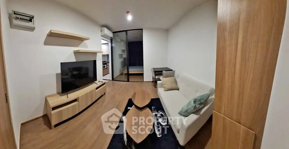 Modern living room with sleek furniture and open layout, featuring a cozy sofa and stylish TV unit.