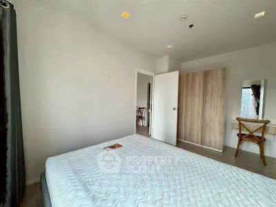 Spacious bedroom with modern decor and ample natural light, featuring a comfortable bed and stylish furnishings.