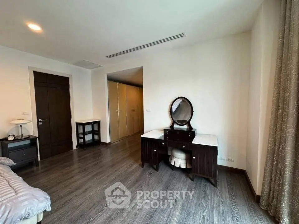 Spacious bedroom with elegant wooden furniture and ample natural light.