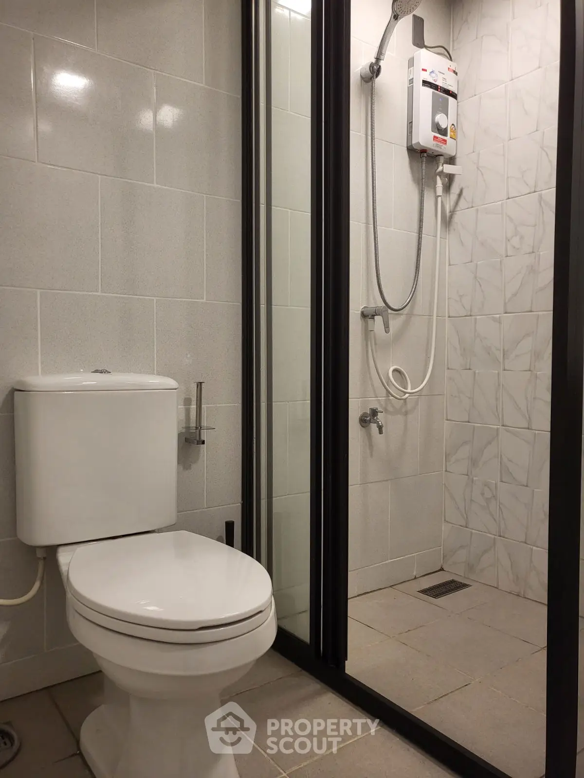 Modern bathroom with sleek shower and toilet in contemporary apartment.