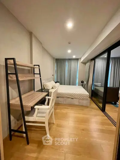 Modern bedroom with wooden flooring and study desk, featuring large windows and elegant curtains.