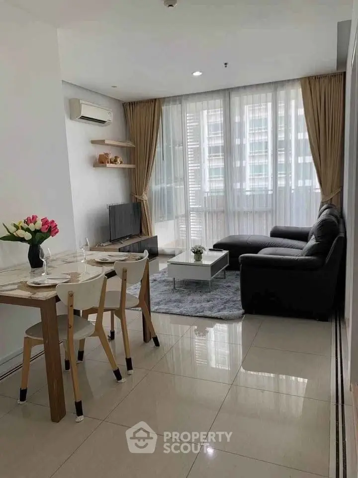 Modern living room with sleek furniture and large windows in a stylish apartment.