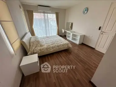 Spacious bedroom with modern decor and large window for natural light