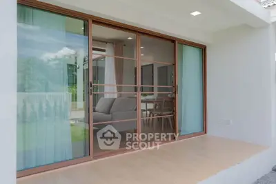 Modern home with sliding glass doors opening to a cozy living area and dining space.